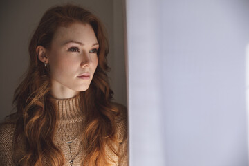 Woman looking out of the window at home