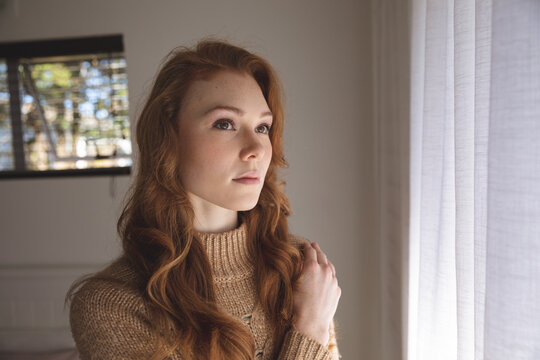 Woman looking out of the window at home