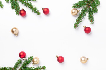 Minimal christmas composition. Fir tree branches with red and gold christmas balls on white background. Top view. Copy space