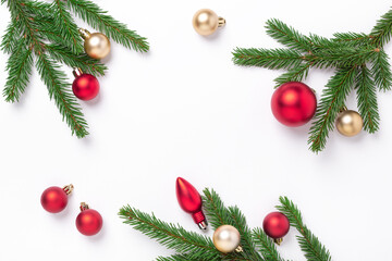 Minimal christmas composition. Fir tree branches with red and gold christmas balls on white background. Top view. Copy space