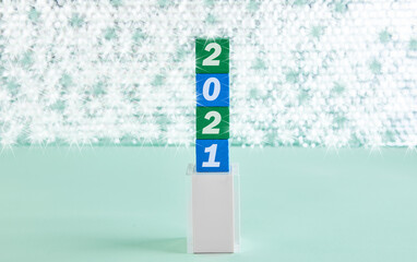 Concept for 2021. Wooden blocks with text and shiny background on the podium