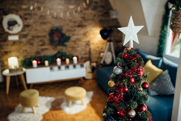 White star shape on top of Christmas tree at home.
