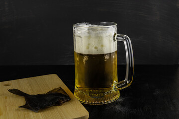 A glass of light beer with salted fish