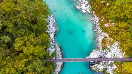 Aerial view of the turquoise blue Soca river (Isonzo) and wooden bridge near Bovec in the Julian Alps