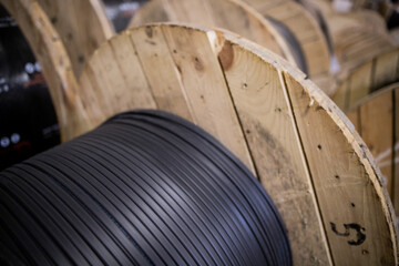 Vertical coils ndustrial wires. Many turns of main electrical cable is closeup. Roll of outdoor...