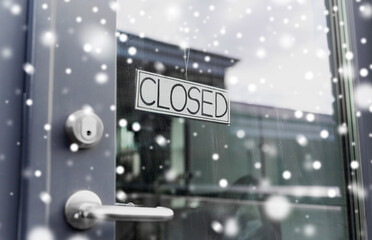 small business, pandemic and service concept - glass door of closed shop or office in winter over...