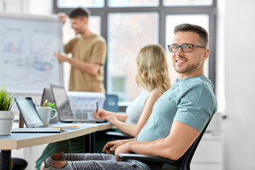 business and people concept - happy smiling man in glasses at office conference