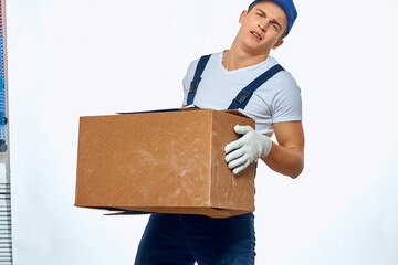 Man worker with box in hands delivery loading service work light background