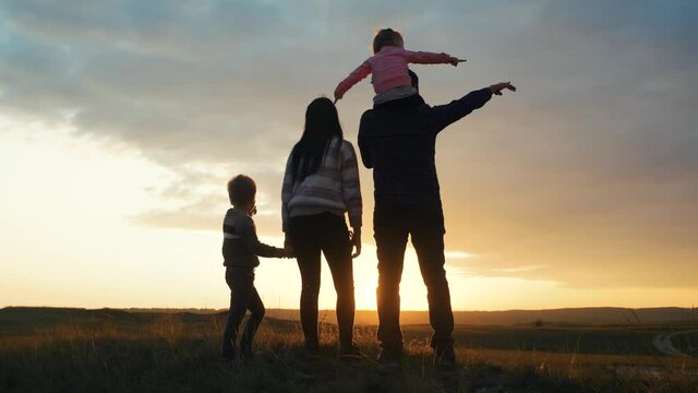 happy family . mom dad and children silhouette a stand at sunset nature sunlight rays. silhouette people teamwork happy family lifestyle walk at sunset nature sun glare