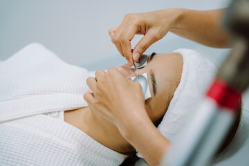 Woman getting spa treatment with protective goggles.