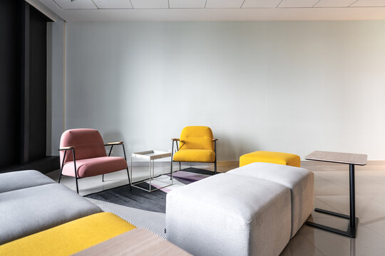 Colorful armchair in minimal modern style with empty wall background in natural light setting / interior / copy space