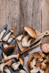 Fresh forest boletus mushrooms on wooden background. Top view. Copy space. Autumn harvest concept. Fresh picked Porcini mushrooms in basket