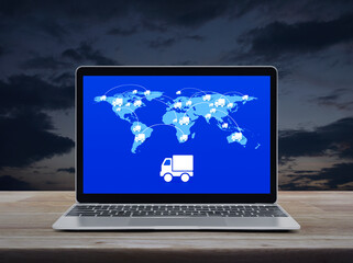 Delivery truck flat icon with connection line and world map on modern laptop computer screen on wooden table over sunset sky, Business transportation online concept, Elements of this image furnished b