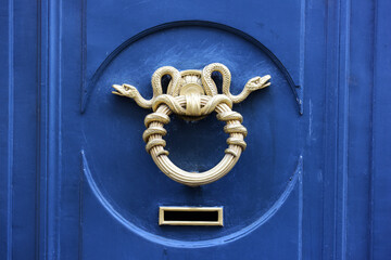 elaborate antique bronze door handle with sinuous metal snakes. Paris, france