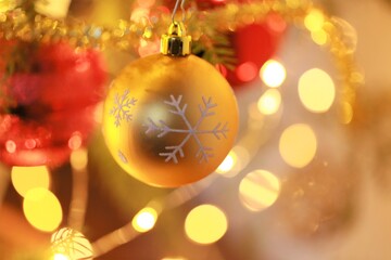 Christmas and New Year background.Golden and red decorative ball and glowing  garlands decoration on the christmas tree.Christmas tree festive decor.Winter holidays symbol.holidays wallpaper 