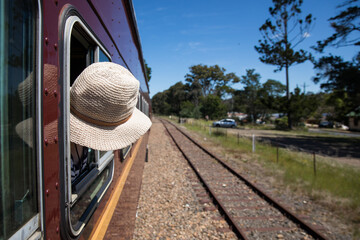 Young child girl with head outside window of vintage train travelling 