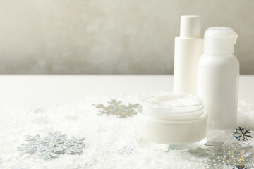 Fototapeta na wymiar Cosmetics on white table with decorative snow