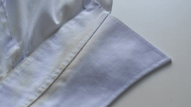 Dirty collar in a white shirt, dirty stains. The concept of bleaching and washing clothes with powder
