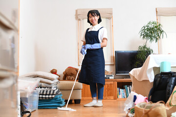 ワイパーで床掃除をする若い女性