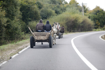 Fototapeta na wymiar Roma people drive a horse drawn cart on a public road.