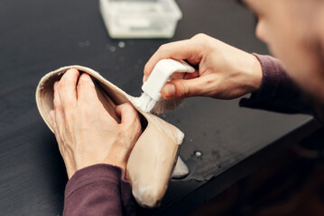 Leather shoes care concept. Shoe cleaning and polishing. Close up picture of woman hands cleaning...