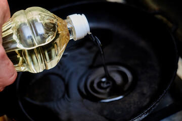 Pour oil into a hot pan. Preparation for frying products.