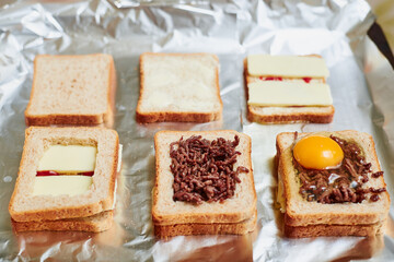 Making sandwiches from toast bread with minced meat, egg and cheese. Different stages of the calculation of the ingredients.