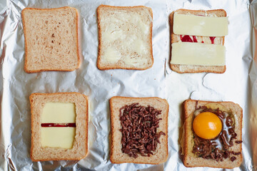 Making sandwiches from toast bread with minced meat, egg and cheese. Different stages of the calculation of the ingredients.