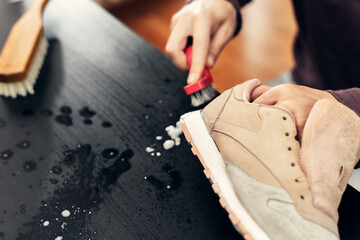 The master cleans the foam sole of the sneakers. washing the dirty sneakers , cleaning the shoes