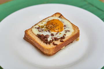Sandwich on toast with minced meat, egg and seasonings.