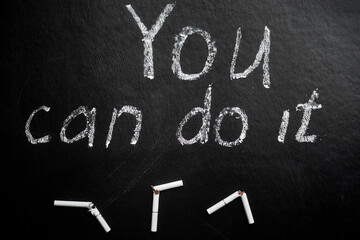 Quit smoking. You can do it- inscription on a black background.