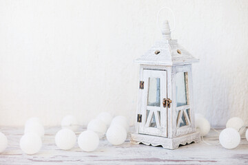 White wooden vintage lantern and white balls on white background. Copy space