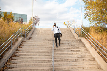 office man walking down park stairs with mask