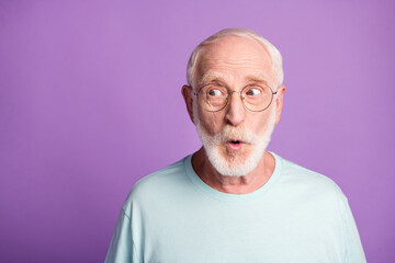 Portrait of surprised pensioner wear light blue t-shirt glasses open mouth empty space isolated on...