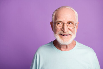 Portrait of beard old man wear light blue t-shirt spectacles look empty space isolated on violet...