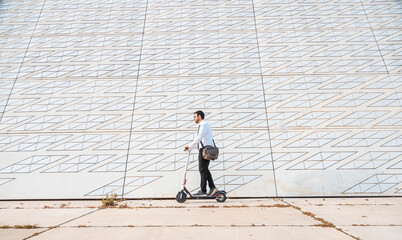 office man goes to work on electric scooter