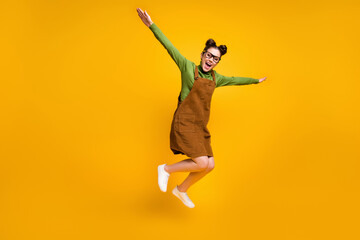 Full length photo of cheerful dreamy girl nerd high school student jump hold hand fly like bird...