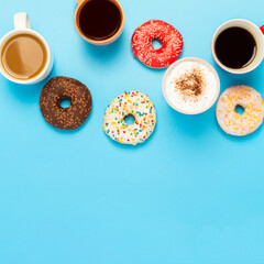 Tasty donuts and cups with hot drinks, coffee, cappuccino, tea on a blue background. Concept of sweets, bakery, pastries, coffee shop, meeting, friends, friendly team. square. Flat lay, top view