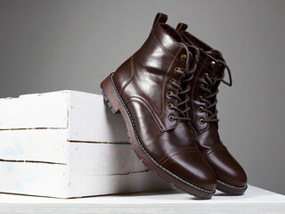 Trendy brown boots with white wooden box