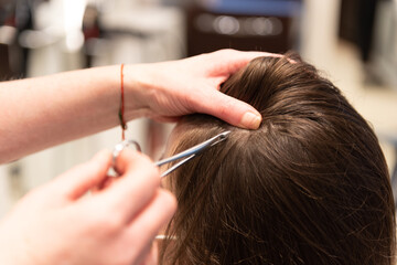 Closeup frame of a hair stylist extracting hair to a client to be analyzed.