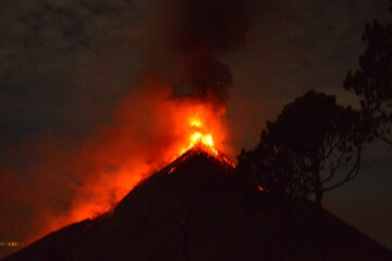 Sunrise hiking and camping on the active Volcan Acatenango with a view to the volcano Fuego eruption - Guatemala