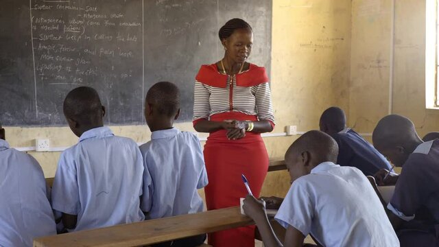 Female teacher with students, teaching in classroom. Africa.