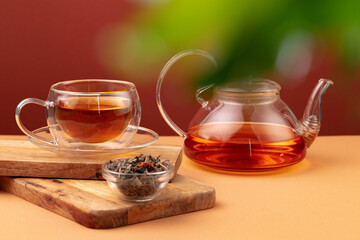 Glass teapot and cup with black tea