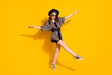 Fototapeta na wymiar Full body photo of crazy candid girl enjoy rejoice dance discotheque raise hands leg wear retro style clothes gumshoes isolated over bright shine color background