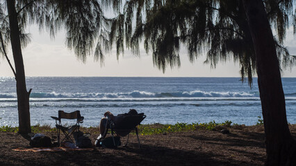 Fototapeta na wymiar People in a chair enjoying the view at the beach