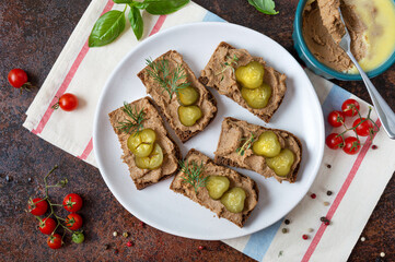 Canapes with chicken liver pate and pickled cucumbers on rye bread. Tasty and healthy appetizer....