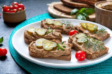 Canapes with chicken liver pate and pickled cucumbers on rye bread. Tasty and healthy appetizer