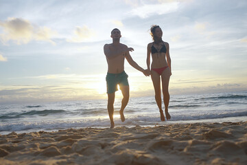 silhouettes of athletes running along the beach / sports summer in the warm sea, healthy rest, sports activity, summer vacation