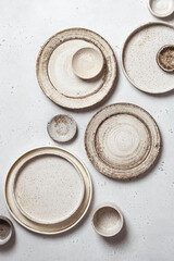 handmade ceramics, empty craft ceramic plates on light background top view