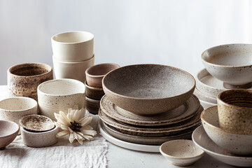 handmade ceramic tableware, empty craft ceramic plates, bowls and cups on light background  - obrazy, fototapety, plakaty